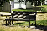 metal commercial commemorative garden bench in a well-maintained backyard