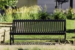 metal commercial commemorative garden bench in a well-maintained backyard