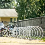 stainless steel commercial outdoor bike racks are placed in the parking area of a national park entrance