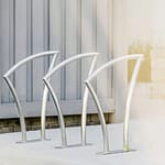 3 stainless steel city bike parking rack is in the sunlight in the community park in downtown Toronto