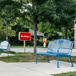 blue commercial outdoor metal garden benches outdoor in the community at Tim Hortons. This bench model is designed for commemorative applications in the parks, on streets, and in gardens