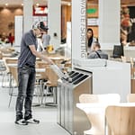 a customer is disposing his lunch waste to our food court recycling receptacle in the mall in downtown Toronto